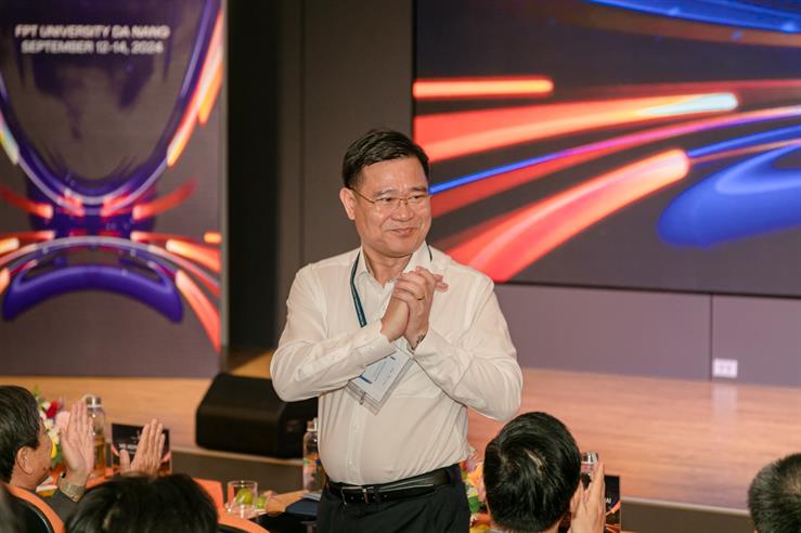 A person standing in front of a group of people clappingDescription automatically generated